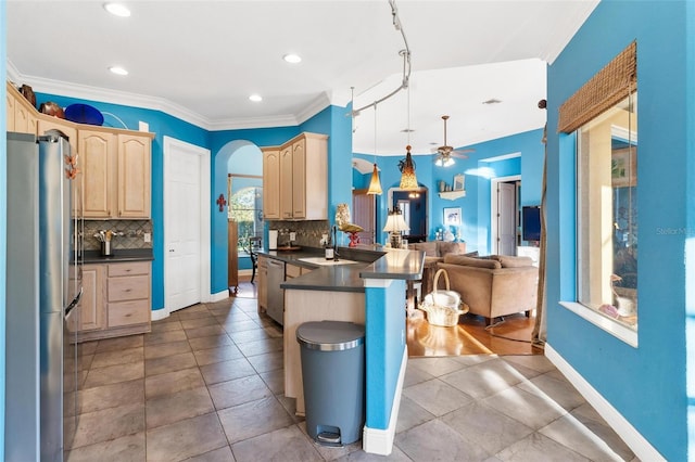 kitchen with ceiling fan, light brown cabinets, stainless steel appliances, kitchen peninsula, and decorative light fixtures