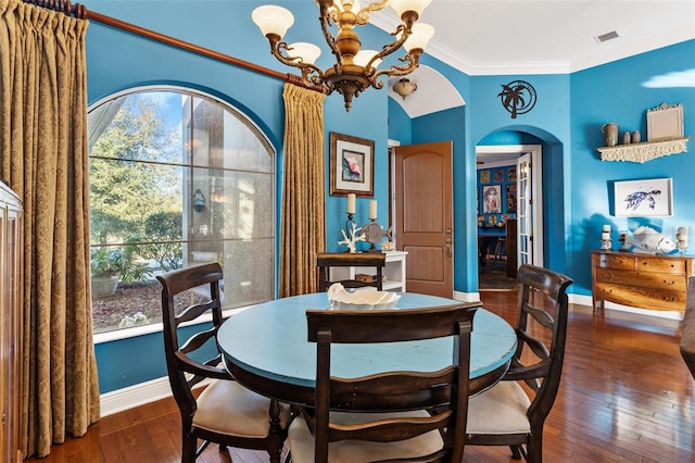 dining space with dark hardwood / wood-style flooring, crown molding, and an inviting chandelier