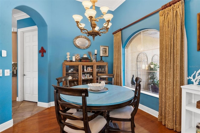 dining room with hardwood / wood-style flooring, a notable chandelier, and ornamental molding