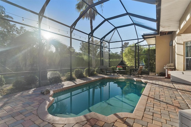 view of pool with glass enclosure, area for grilling, and a patio