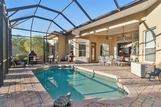 view of swimming pool with a patio area, ceiling fan, and glass enclosure