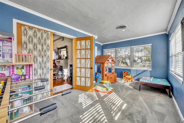 game room featuring crown molding, a fireplace, carpet floors, and a textured ceiling