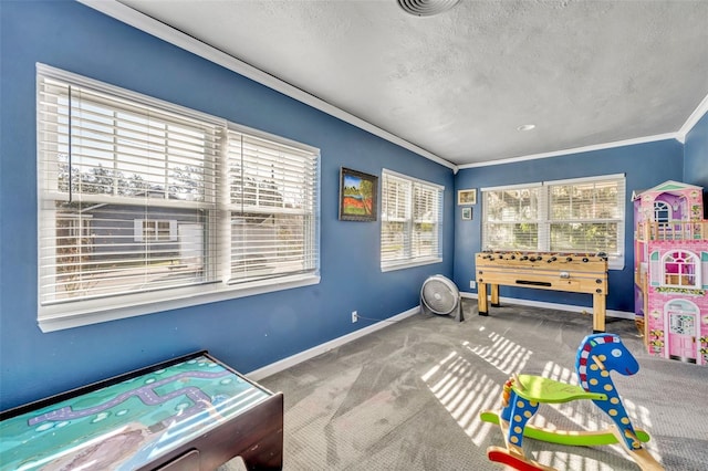 playroom featuring plenty of natural light, carpet, a textured ceiling, and ornamental molding