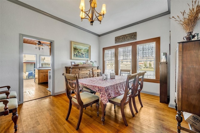 dining space with ornamental molding, ceiling fan with notable chandelier, and light wood-type flooring