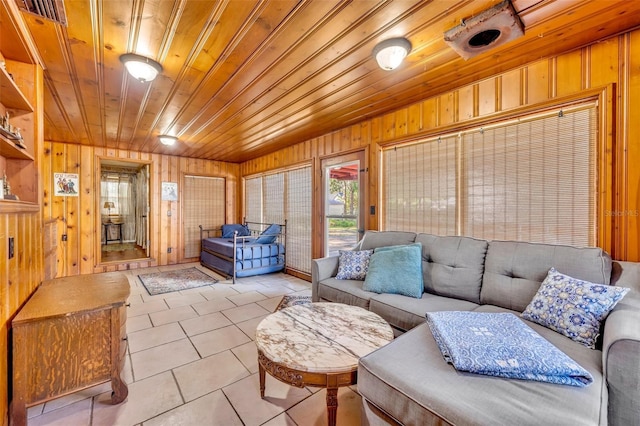 living room featuring wooden walls, light tile patterned floors, and wood ceiling