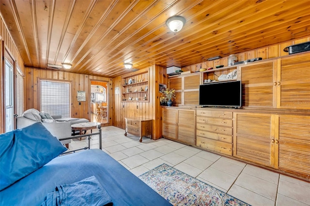 living room with a wealth of natural light, light tile patterned floors, and wood walls