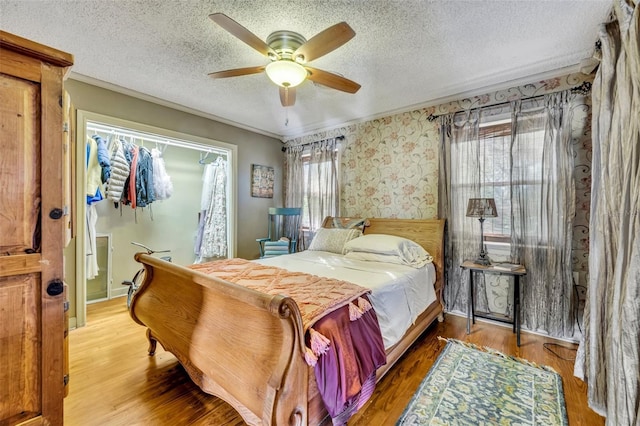 bedroom with ceiling fan, wood-type flooring, and multiple windows