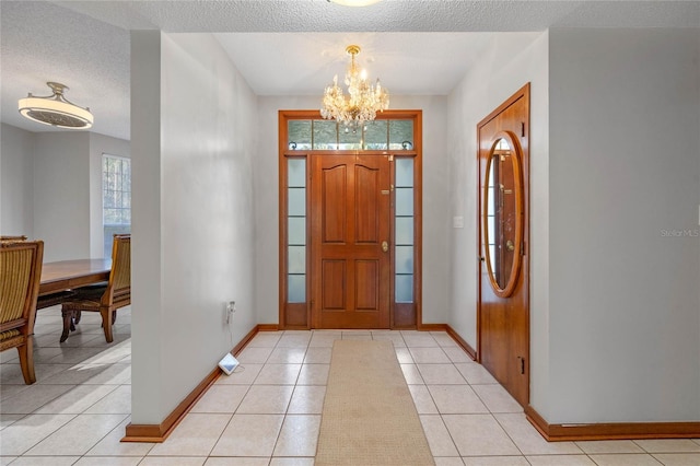 tiled entryway featuring a chandelier and a textured ceiling