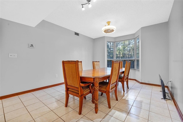 tiled dining room with a textured ceiling