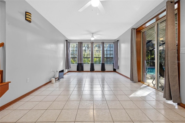 empty room with ceiling fan, light tile patterned flooring, and vaulted ceiling