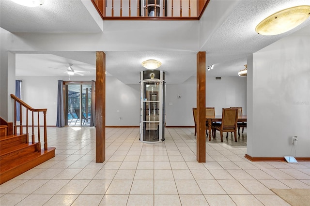 interior space featuring light tile patterned floors, a textured ceiling, and ceiling fan