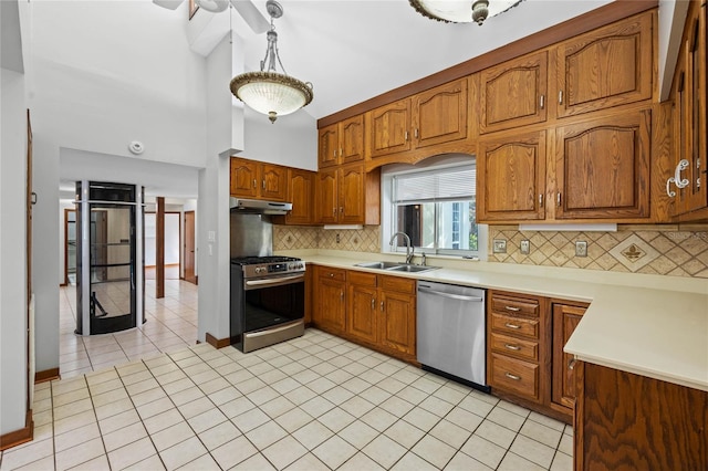 kitchen featuring decorative backsplash, stainless steel appliances, sink, decorative light fixtures, and light tile patterned flooring