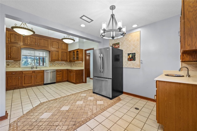 kitchen featuring a notable chandelier, sink, hanging light fixtures, and appliances with stainless steel finishes