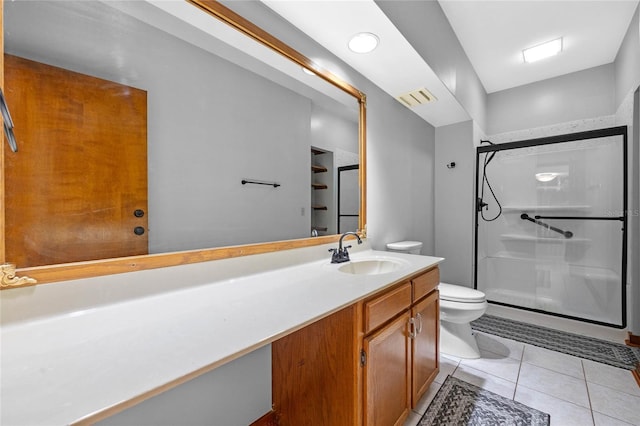 bathroom with tile patterned floors, vanity, toilet, and an enclosed shower