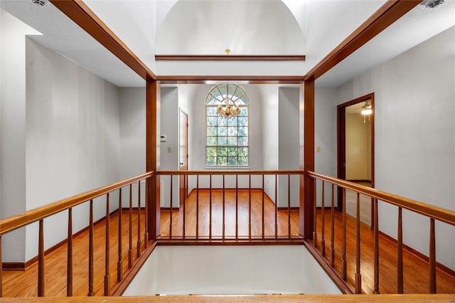 hall featuring light wood-type flooring and an inviting chandelier