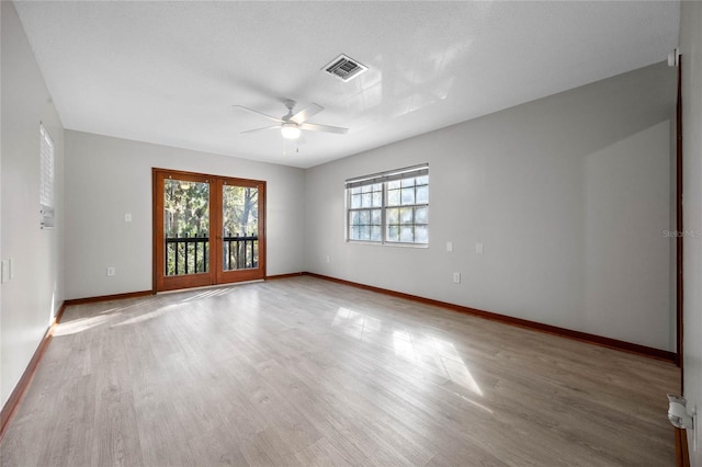 spare room featuring a textured ceiling, ceiling fan, hardwood / wood-style floors, and french doors