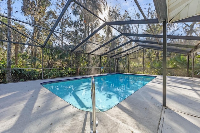 view of swimming pool with glass enclosure and a patio