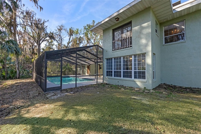 exterior space with a lawn and glass enclosure