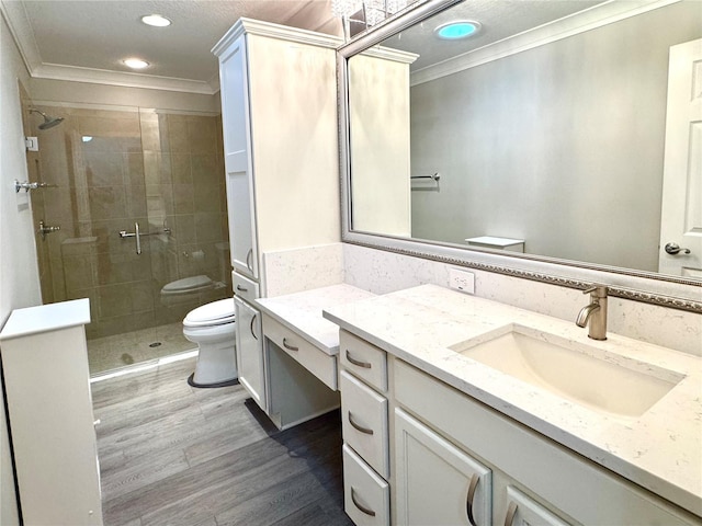 bathroom featuring an enclosed shower, vanity, crown molding, hardwood / wood-style floors, and toilet