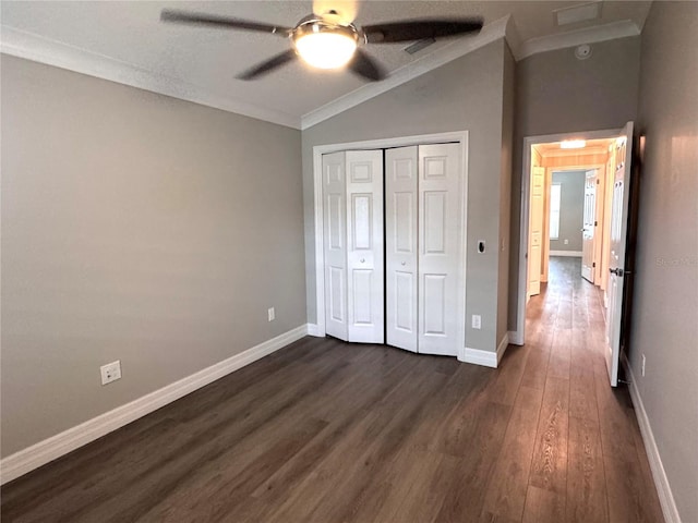 unfurnished bedroom featuring ceiling fan, dark hardwood / wood-style flooring, vaulted ceiling, a closet, and ornamental molding