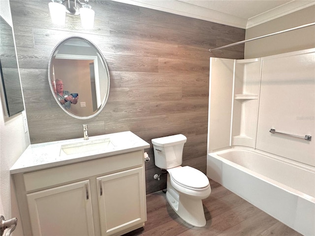 full bathroom featuring washtub / shower combination, wood walls, hardwood / wood-style floors, toilet, and vanity