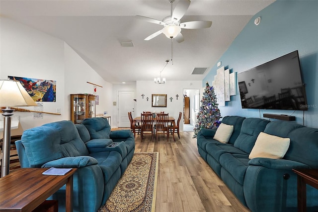 living room featuring light hardwood / wood-style flooring, ceiling fan with notable chandelier, and lofted ceiling