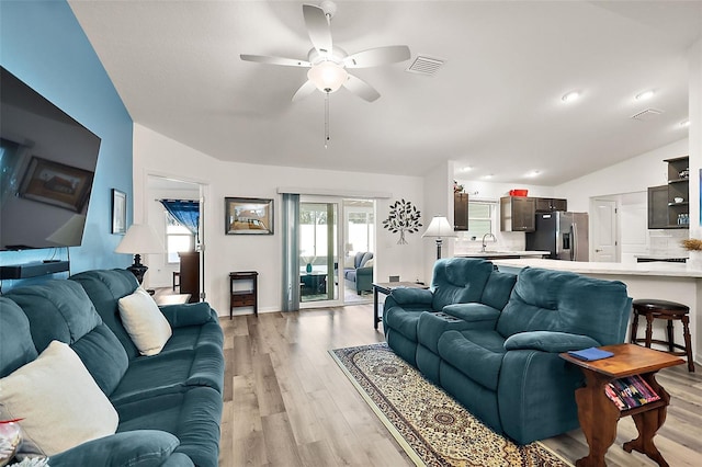 living room featuring light hardwood / wood-style floors, ceiling fan, lofted ceiling, and sink