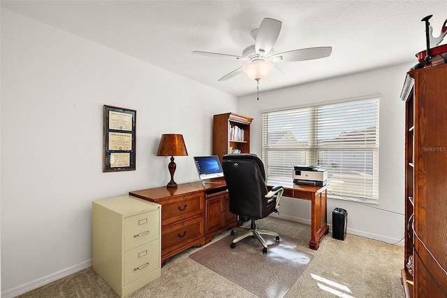 carpeted home office featuring ceiling fan