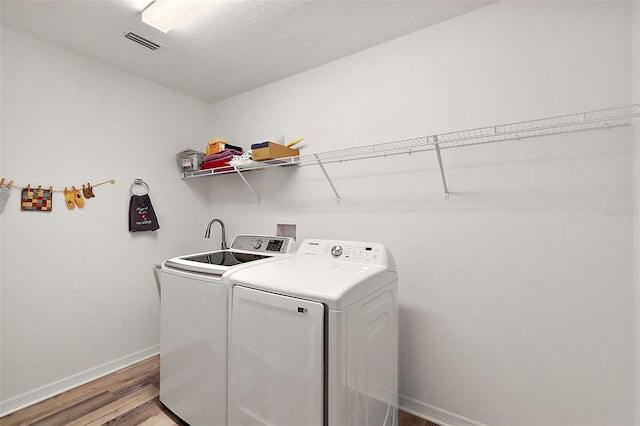 laundry room with hardwood / wood-style flooring and washing machine and clothes dryer