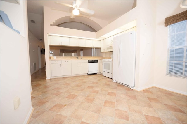 kitchen with white appliances, ceiling fan, sink, white cabinets, and lofted ceiling