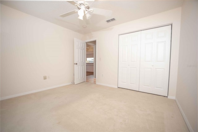 unfurnished bedroom with ceiling fan, light colored carpet, and a closet