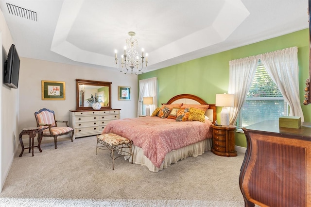 carpeted bedroom with a chandelier and a tray ceiling