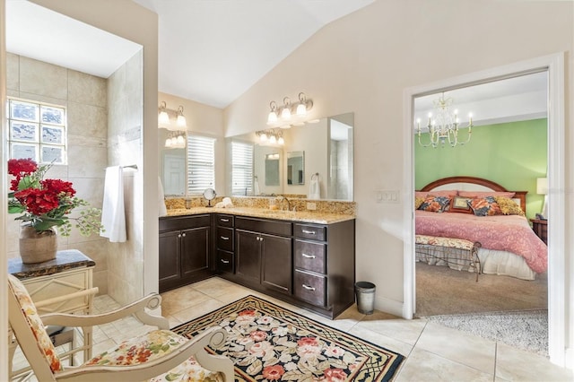 bathroom with tile patterned floors, vanity, a chandelier, and lofted ceiling