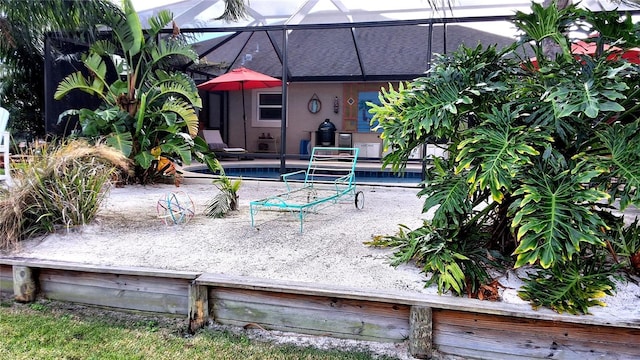 view of pool with glass enclosure and a patio area