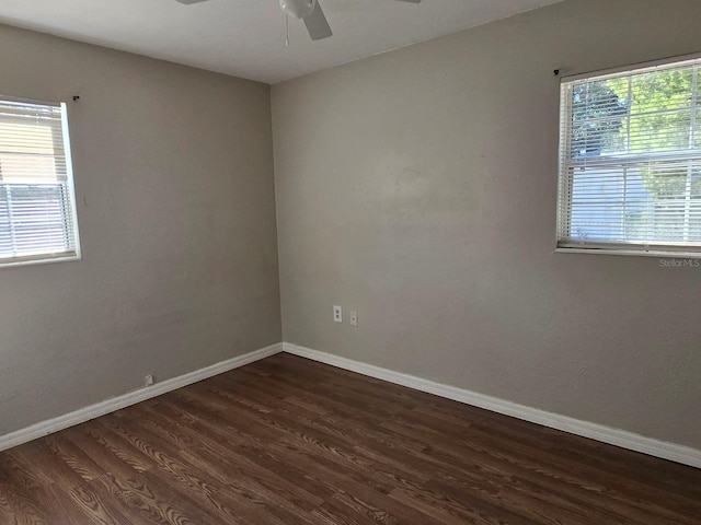 empty room with ceiling fan and dark wood-type flooring