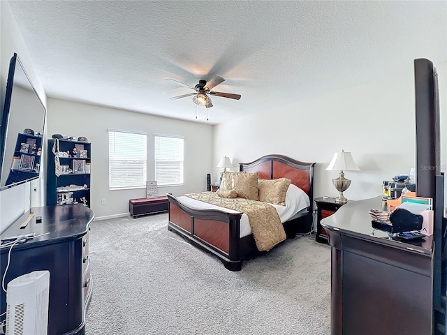 carpeted bedroom featuring ceiling fan and a textured ceiling