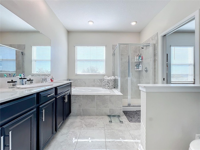 bathroom featuring tile patterned floors, vanity, a healthy amount of sunlight, and independent shower and bath