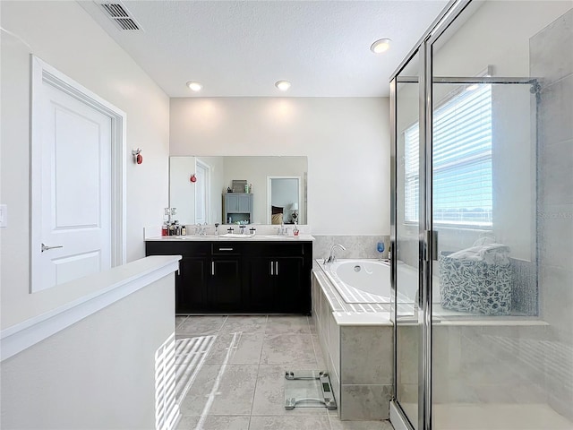 bathroom with tile patterned flooring, vanity, separate shower and tub, and a textured ceiling