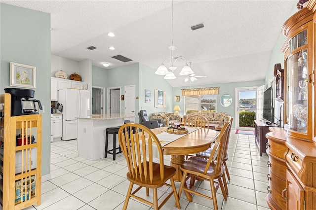 tiled dining space with ceiling fan with notable chandelier and a textured ceiling