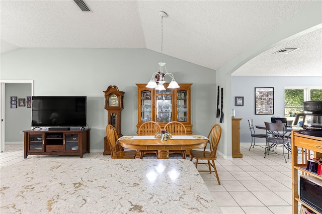 dining space with tile patterned flooring, a textured ceiling, and lofted ceiling