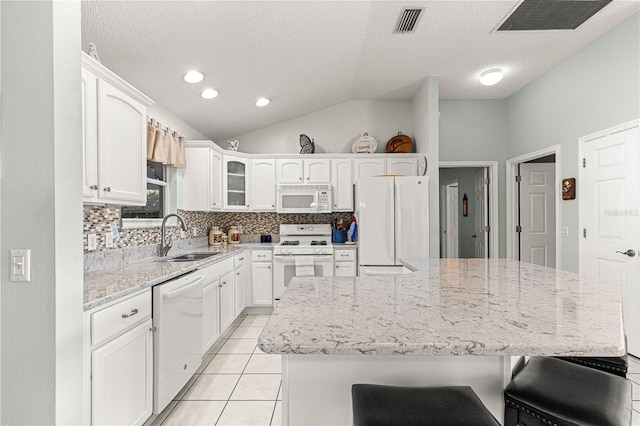 kitchen featuring a center island, sink, vaulted ceiling, white appliances, and white cabinets