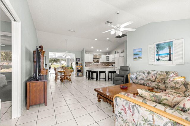 living room with a wealth of natural light, light tile patterned floors, and lofted ceiling