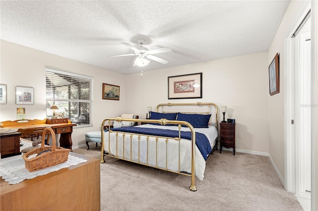 bedroom with a textured ceiling, light colored carpet, and ceiling fan