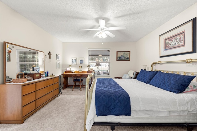 carpeted bedroom featuring a textured ceiling and ceiling fan