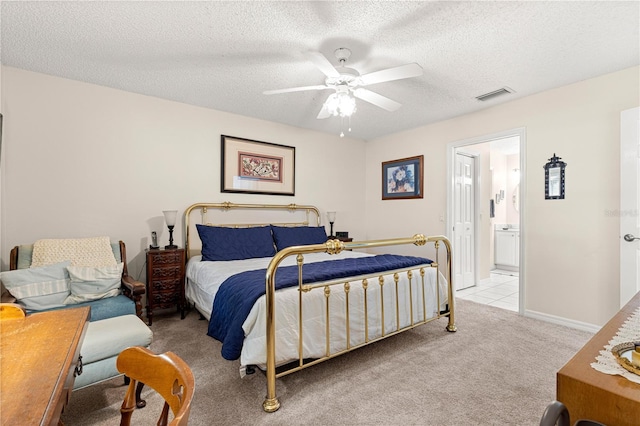 carpeted bedroom featuring ensuite bath, ceiling fan, and a textured ceiling