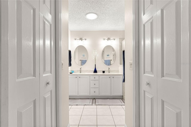 bathroom featuring tile patterned flooring, a textured ceiling, and vanity