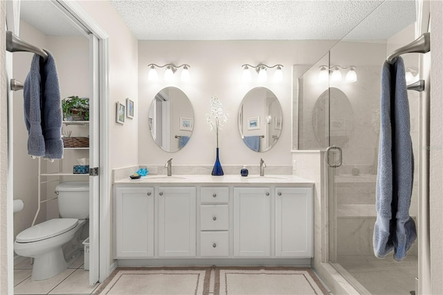 bathroom featuring tile patterned floors, a textured ceiling, vanity, toilet, and a shower with shower door