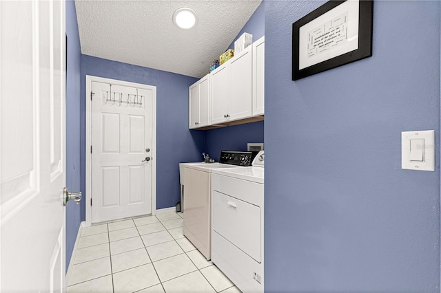 laundry room with cabinets, independent washer and dryer, a textured ceiling, and light tile patterned floors