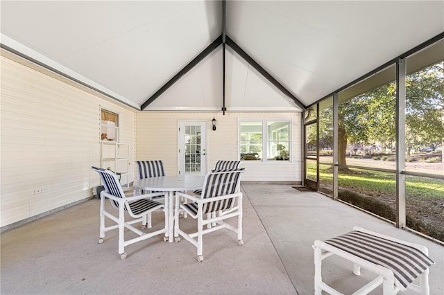 sunroom featuring lofted ceiling with beams