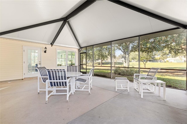 unfurnished sunroom featuring lofted ceiling with beams